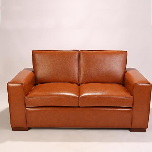 Sofa en cuir au tracé moderne. Le canapé est réalisable entièrement sur mesure. Le revêtement en cuir marron caramel.